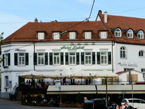 een groot wit gebouw met parasols ervoor bij Hotel Kredell in Neckargemünd