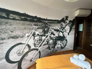 een muurschildering van drie mannen op motorfietsen aan een muur bij ATICO Catedral Barbacoa y Aire sin ascensor in Logroño