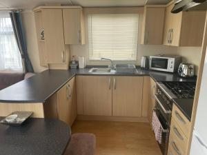 a small kitchen with a sink and a microwave at Swift Holiday Caravan Rockley Park in Lytchett Minster