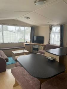 a living room with a couch and a table at Swift Holiday Caravan Rockley Park in Lytchett Minster