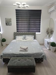 1 dormitorio con cama y ventana grande en Apartman u centru, en Šid