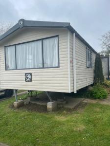 un gran remolque blanco está estacionado en un patio en Swift Holiday Caravan Rockley Park, en Lytchett Minster