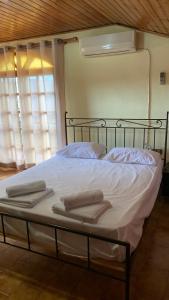 - une chambre avec un lit et des serviettes dans l'établissement Εξοχική κατοικία με σοφίτα, à Chalcis