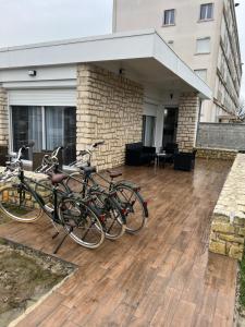 Maison Bel Air في لا روشيل: مجموعة من الدراجات متوقفة على سطح خشبي
