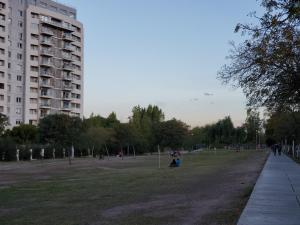 a park with people walking and a building at Apartamento en Mendoza in La Cieneguita