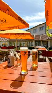 Dwa kieliszki piwa na drewnianym stole w obiekcie Hotel am Park Bad Driburg w mieście Bad Driburg