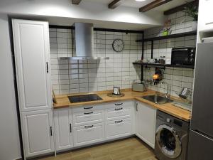 a kitchen with white cabinets and a washing machine at Casas Piedra in Arredondo