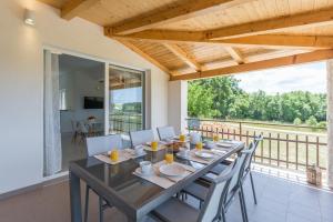 una sala da pranzo con tavolo e sedie e un balcone di Villa Aria private Pool near Vrsar a Vrsar