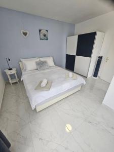 a bedroom with a large white bed with towels on it at Apartments Aurora in Jezera