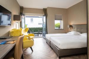 une chambre d'hôtel avec un lit, une table et des chaises dans l'établissement Hotel De Lindeboom, à Den Burg