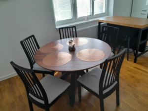 a dining room table with four chairs and a wooden table at Apartmán centrum Bytča. in Bytča