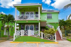 a green house with a balcony at Best E Villas Prospect St James in Saint James