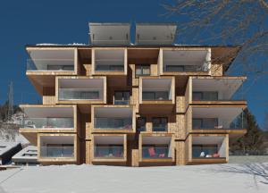 ein Gebäude mit Balkon im Schnee in der Unterkunft Haus am Sonnenhang by Schladming Appartements in Schladming