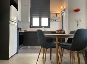 eine Küche und ein Esszimmer mit Tisch und Stühlen in der Unterkunft Ήφαιστος - Ifestos in Tríkala