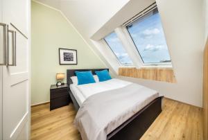 a bedroom with a bed with blue pillows and a window at Citadines South Vienna in Vienna +41 photos