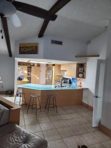 una cucina con bancone blu e sgabelli di Hideaway in Serenity! a Clearwater