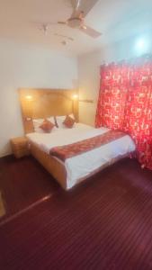 um quarto com uma cama grande e uma cabeceira em tons de vermelho em THE Q2 RESIDENCY em Srinagar