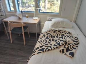 Habitación con cama, escritorio y escritorio. en Hotel Linnasmäki en Turku