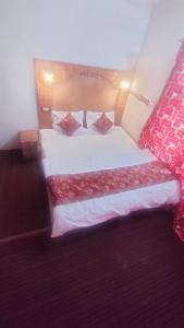um quarto com uma cama grande com lençóis vermelhos e brancos em THE Q2 RESIDENCY em Srinagar