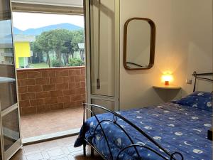 Schlafzimmer mit einem Bett und Blick auf einen Balkon in der Unterkunft La Perla di Luni Mare Casa Vacanze in Fiumaretta di Ameglia