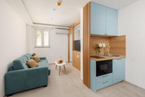 un salon avec un canapé bleu et une cuisine dans l'établissement Ocea Studio Apartments, à Kotor