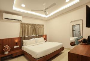 a bedroom with a bed and a ceiling fan at Arjun - A boutique hotel in Haridwār