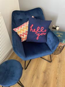 a blue chair with a pillow with the words help you at The Coach House & The Stables Holiday Homes Windy Bank Hall Green Moor Yorkshire Peak District in Wortley