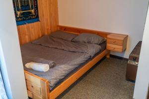 a small bed in a room with a wooden frame at Hiška Gmajna in Slovenj Gradec