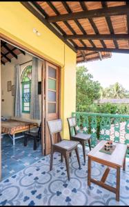 a patio with chairs and a table and a bed at Villa Agastya in Betalbatim