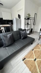 un sofá negro sentado en una sala de estar en New & Refurbished Central Kingston Studio en Kingston upon Thames