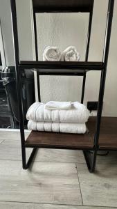 a stack of towels on a shelf in a room at New & Refurbished Central Kingston Studio in Kingston upon Thames