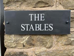 a sign on the side of a stone wall at The Coach House & The Stables Holiday Homes Windy Bank Hall Green Moor Yorkshire Peak District in Wortley