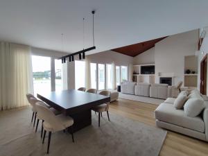 a dining room and living room with a table and chairs at NR Suites - Alojamento Local in Mealhada