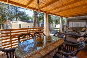een patio met een tafel en stoelen op een veranda bij Adriakamp Mobilehome - Camp Soline in Biograd na Moru