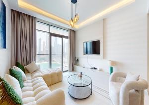 a living room with a couch and chairs and a tv at Amazing View Marina Vista High Floor in Dubai