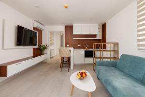 un salon avec un canapé bleu et une table dans l'établissement Ocea Studio Apartments, à Kotor