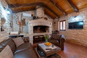 - un salon avec un canapé et une cheminée en pierre dans l'établissement Stone villa Tea with pool, à Posedarje