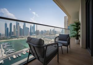 a balcony with two chairs and a view of a city at Amazing View Marina Vista High Floor in Dubai