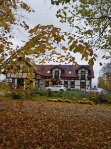 una grande casa con macchine parcheggiate di fronte di Gandelinka Park Kędrzyno 