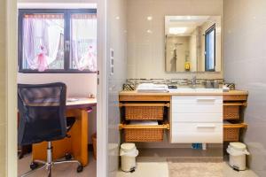 a bathroom with a desk and a chair and a mirror at Le Chalet des Fanières in Chartres