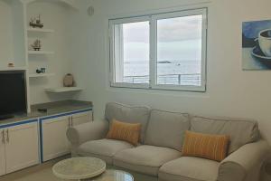 sala de estar con sofá y ventana en La Caleta casa junto al mar en Adeje