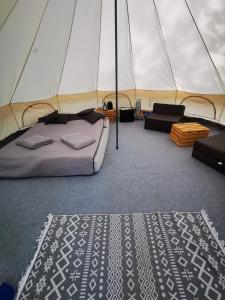 ein Schlafzimmer in einem Zelt mit einem Bett und einem Teppich in der Unterkunft Glamping Kaliska in Łochów