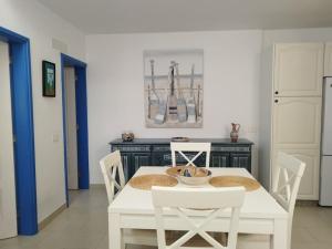comedor con mesa blanca y sillas en La Caleta casa junto al mar en Adeje