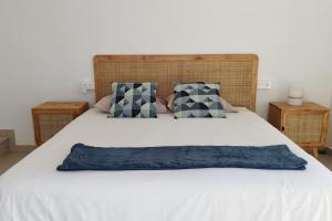 Una cama grande con una almohada azul. en La Caleta casa junto al mar en Adeje