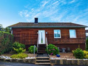 a wooden house with a white door and stairs at Modernes Rhombushaus im Naturparadies Sauerland in Balve