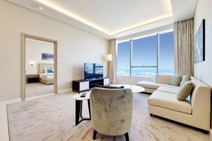 a living room with a couch and a chair at Splendor 1BR with Breathtaking Palm Views in Dubai
