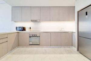 a white kitchen with white cabinets and a sink at Splendor 1BR with Breathtaking Palm Views in Dubai