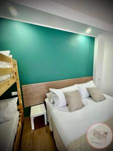 1 dormitorio con 1 cama grande y pared verde en Easy Room en Catania