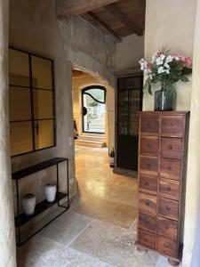 um quarto com uma cómoda com um vaso de flores em 18 Nostra - une maison de charme dans le centre historique em Saint-Rémy-de-Provence