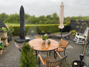eine Terrasse mit einem Tisch, Stühlen und einem Sonnenschirm in der Unterkunft Velindrettet rækkehus med fantastisk udsigt in Næstved